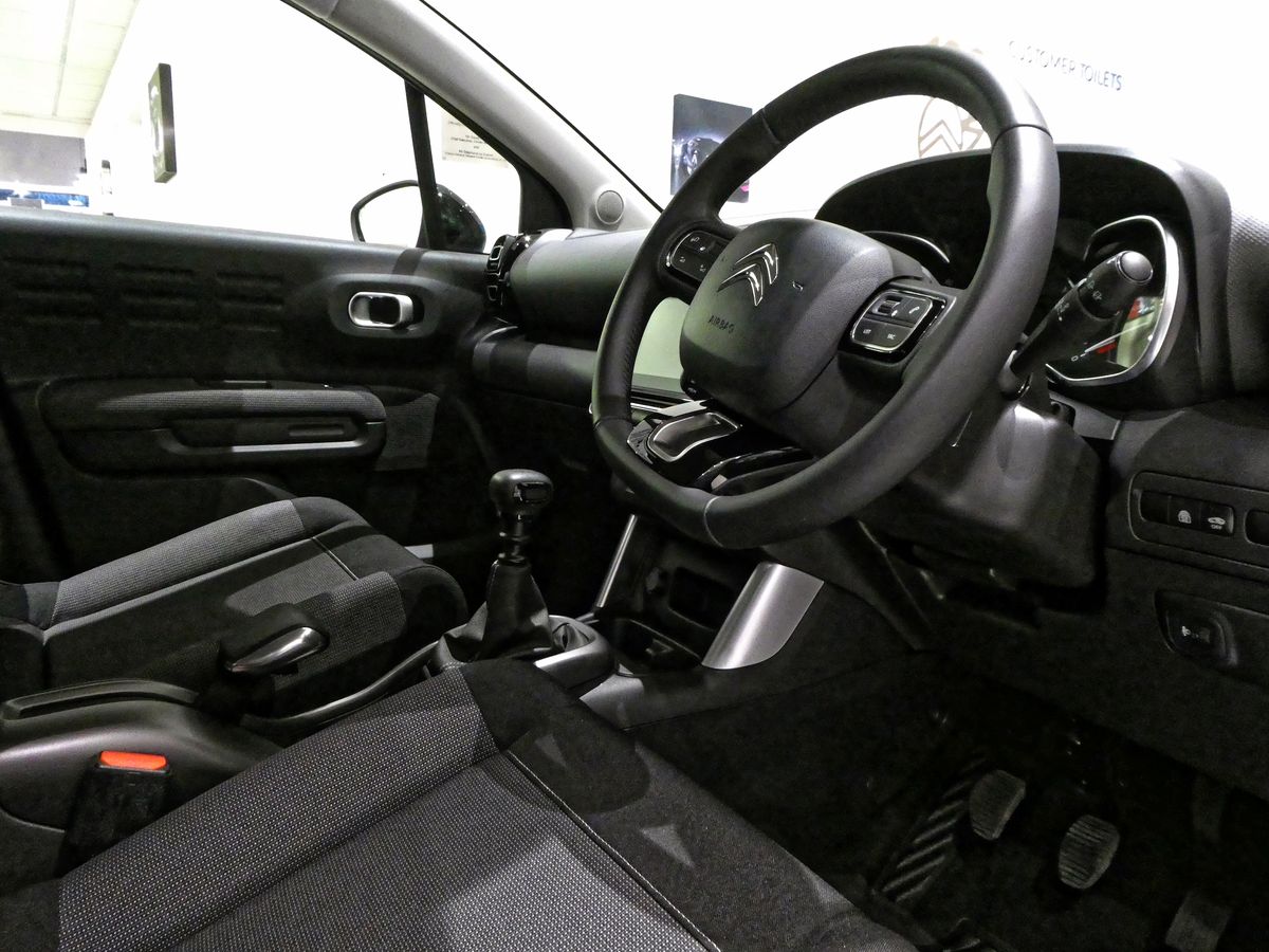 Interior cockpit of a modern car showing the dashboard, steering wheel and front seats