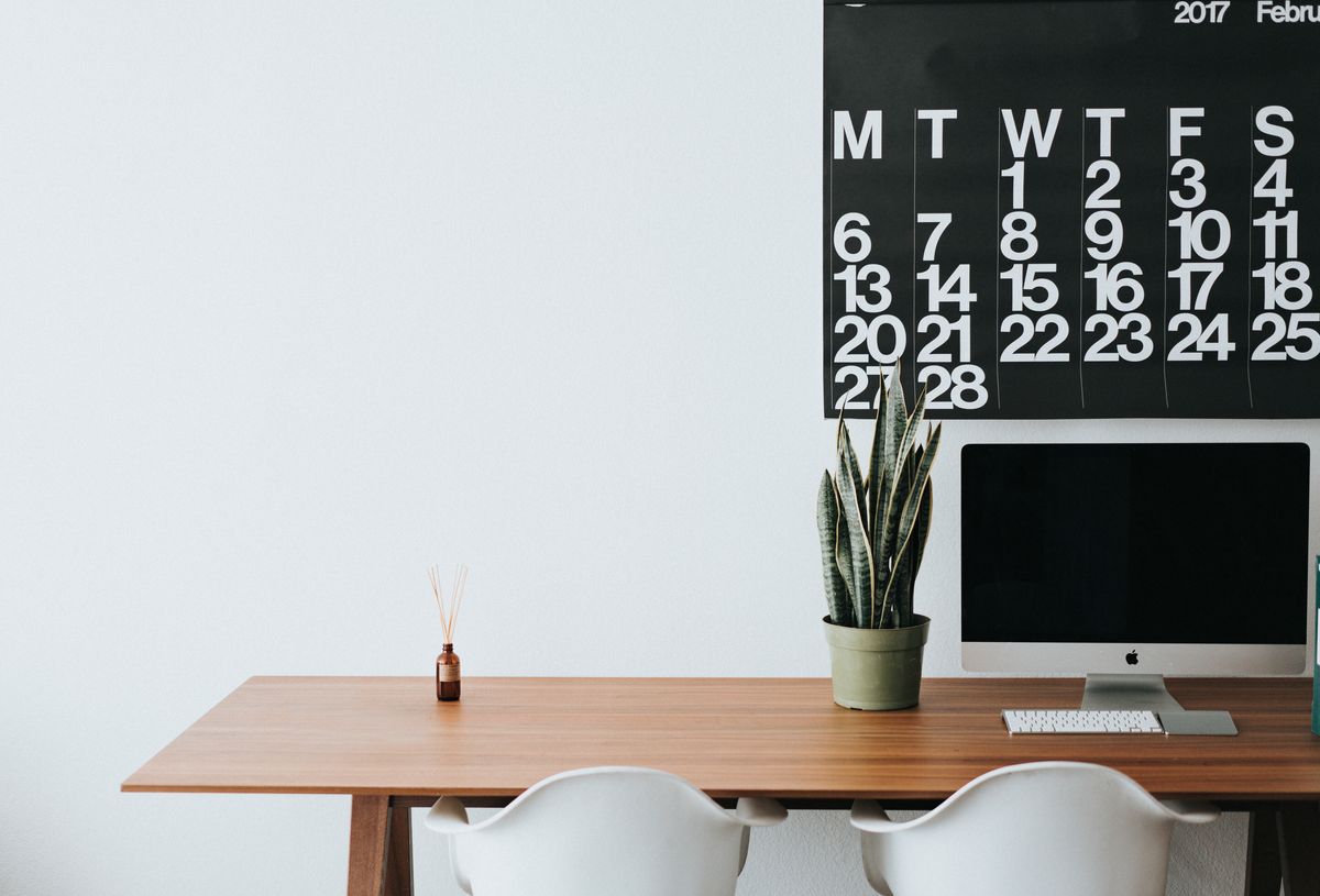 A clean, tidy office desk with a computer in a bright workspace