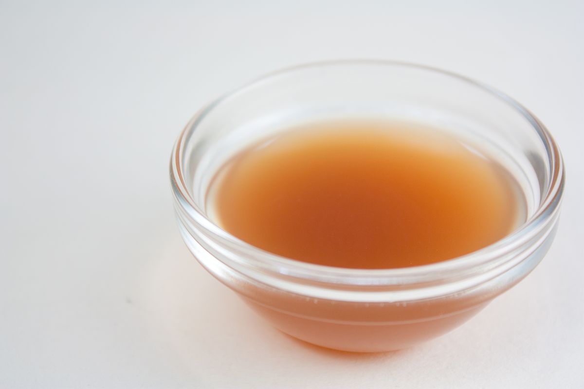 A small glass bowl of apple cider vinegar, a classic bait for luring fruit flies
